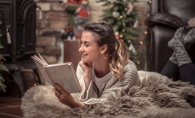 Woman reading a book in a cozy home Christmas atmosphere