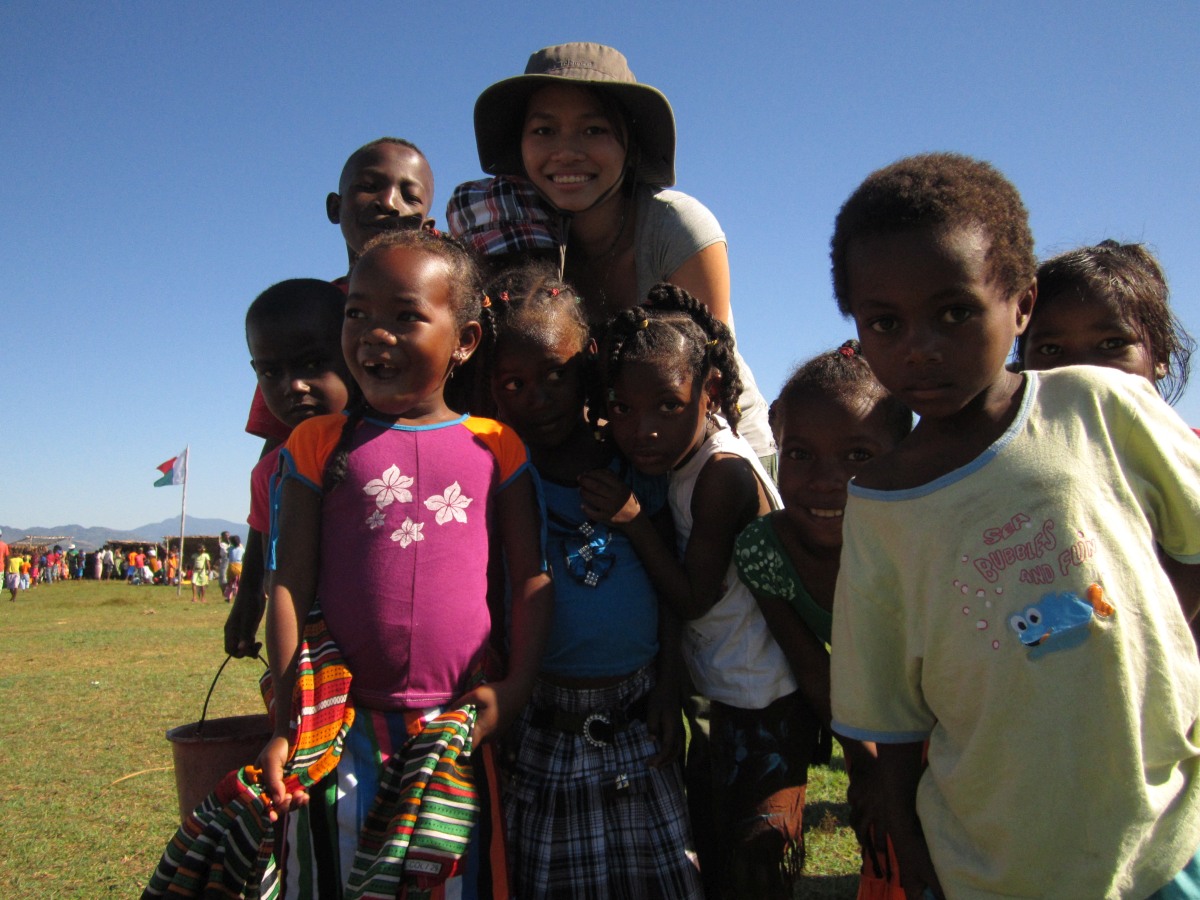 Trang Nguyen with local children in Madagascar, highlighting her community engagement and conservation work.