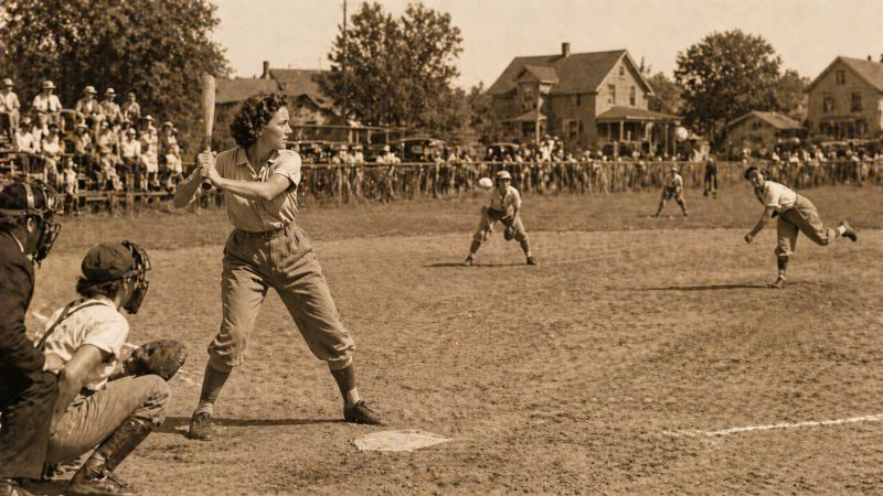 Sepia-toned image of a vintage baseball game with a young female batter at home plate, a catcher and pitcher in action, fielders positioned across the dusty field, and spectators watching from the sidelines in a small-town setting., Image created with AI