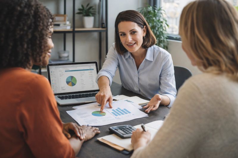  Financial educator explaining budgeting and financial concepts to two women, helping them understand money and make informed decisions. Image created with AI