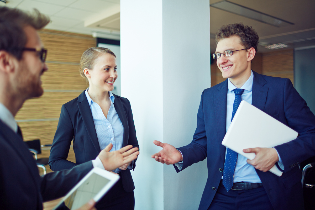 Business professionals smiling and introducing themselves before a meeting in a modern office; Source: https://www.magnific.com/free-photo/young-worker-smiling-with-his-workmates_867711.htm
