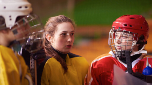 young female hockey players listening to their teammates during a break in the game. Source: https://www.magnific.com/premium-photo/young-teen-girls-ice-hockey-players-team-group-meeting-with-trainer-sport-arena-indoors_36361130.htm