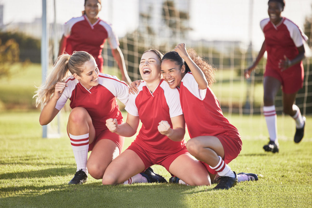 Young women’s football team celebrating a victory together on the field. Source: https://www.magnific.com/premium-photo/celebrate-winning-success-female-football-players-with-fist-pump-hurray-expression-soccer-team-girls-friends-field-cheering-with-victory-sign-celebrating-win-sports-match_30900193.htm 