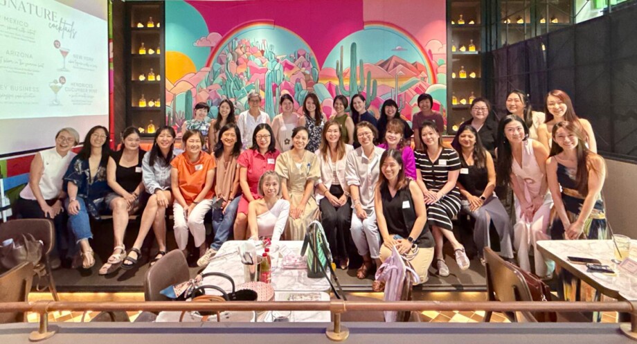 Members of the Mumpreneurs Go Places community pose for a group photo in front of a colorful mural. Photo credit: Photo courtesy of Katherine Lu.